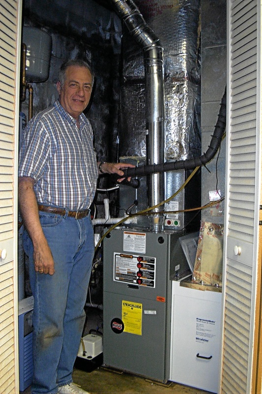 Dr. Bob Gold happily posing next to his new 16 SEER Ruud Air Conditioning, 80%  variable speed furnace with enhanced filtration for his upstairs, as well as a 13 S.E.E.R Air Conditioning, 80% variable speed efficiency furnace with enhanced filtration for his downstairs in February of 2010.
